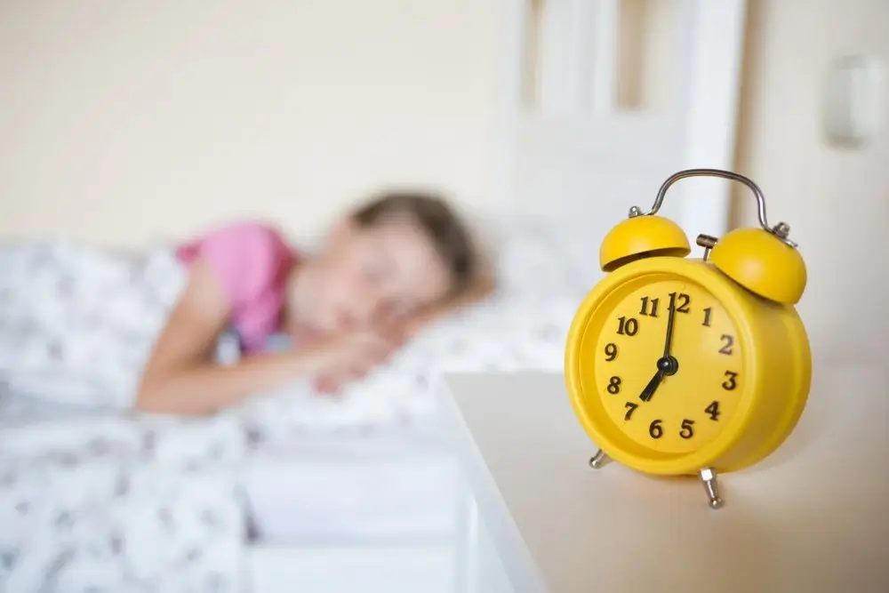 A colorful alarm clock on a child's nightstand.